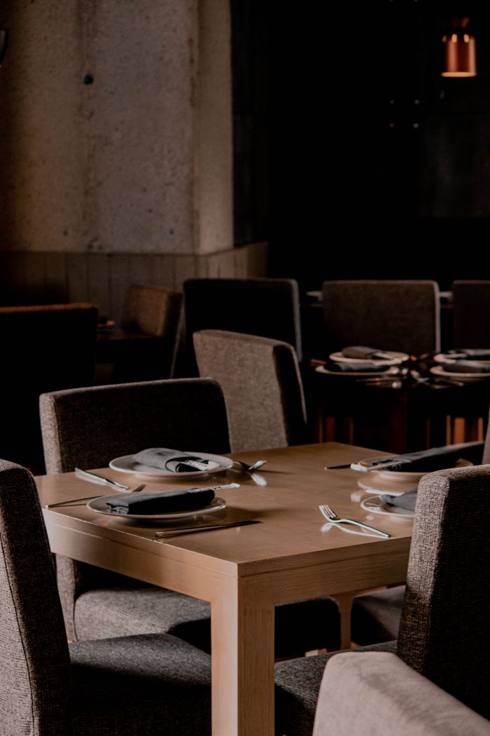 Chic restaurant setting with modern decor, chairs, and a beautifully set table ready for dining.
