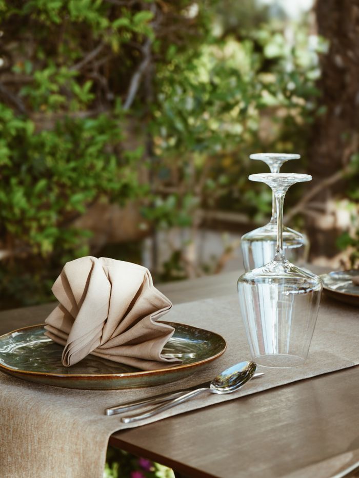 Charming outdoor dining table in Durrës, Albania, with neatly arranged cutlery and glassware.